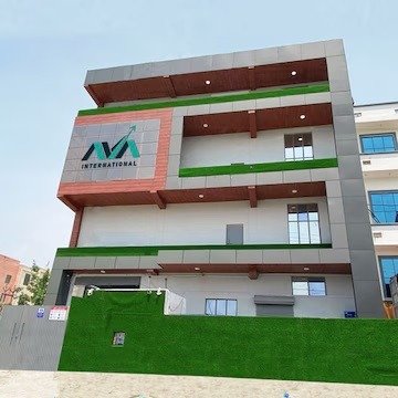 Exterior view of a multi-story commercial building featuring modern grey and wood-textured cladding, green accent turf along balconies, and a prominent AVA International logo.