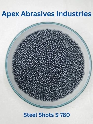 A circular dish filled with small, spherical metallic S-780 steel shots, labeled for Apex Abrasives Industries.