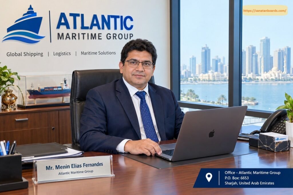 Mr. Menin Elias Fernandes seated at a executive office desk in front of a laptop, with the Atlantic Maritime Group logo and a city skyline background.